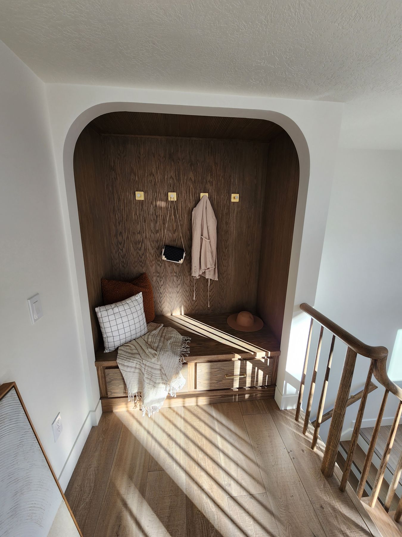 Red oak pole-wrap sitting area with built-in drawers
